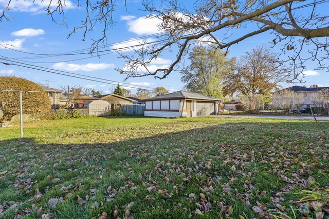 a view of a house with a big yard and large trees