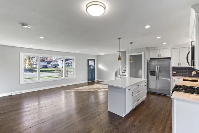 a large kitchen with stainless steel appliances granite countertop a lot of counter space and wooden floor