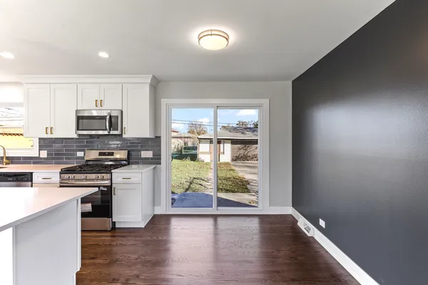 a kitchen with stainless steel appliances granite countertop a stove a sink and a microwave