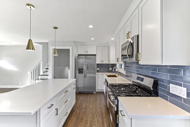 a kitchen with stainless steel appliances a stove a sink a refrigerator and cabinets