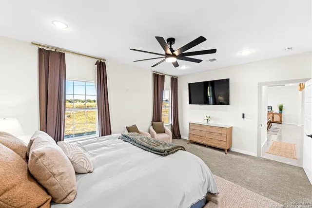a bedroom with a bed window and flat screen tv