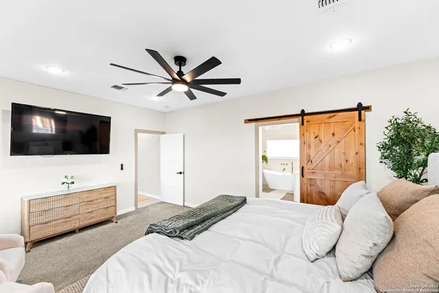 a bedroom with a bed and a flat screen tv