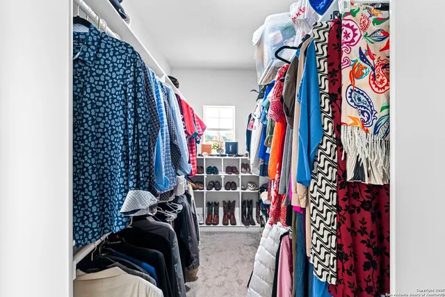 a view of walk in closet with clothes