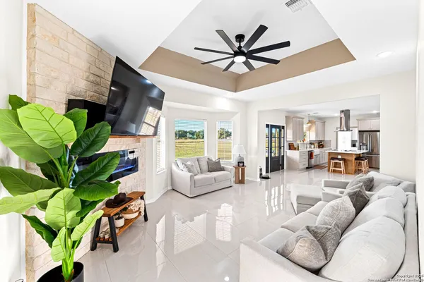 a living room with furniture a large window with a potted plant