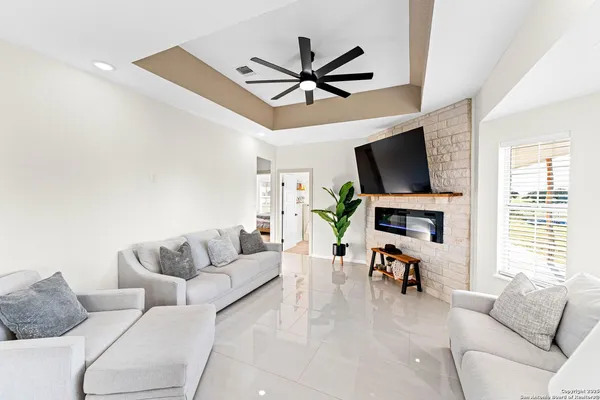 a living room with furniture a ceiling fan and a window