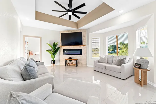 a living room with furniture a flat screen tv and a large window