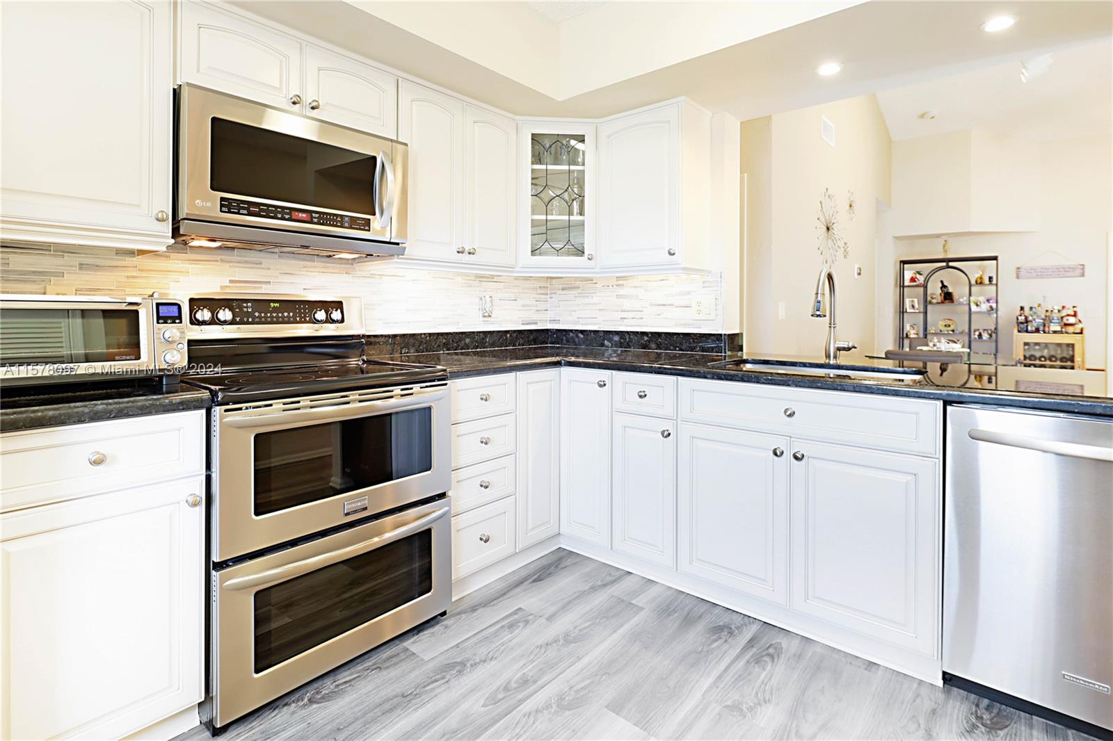 7864 Granada Place, Unit 504 Boca Raton, FL 33433 - Photo 19 of 65 a kitchen with granite countertop cabinets stainless steel appliances and wooden floor