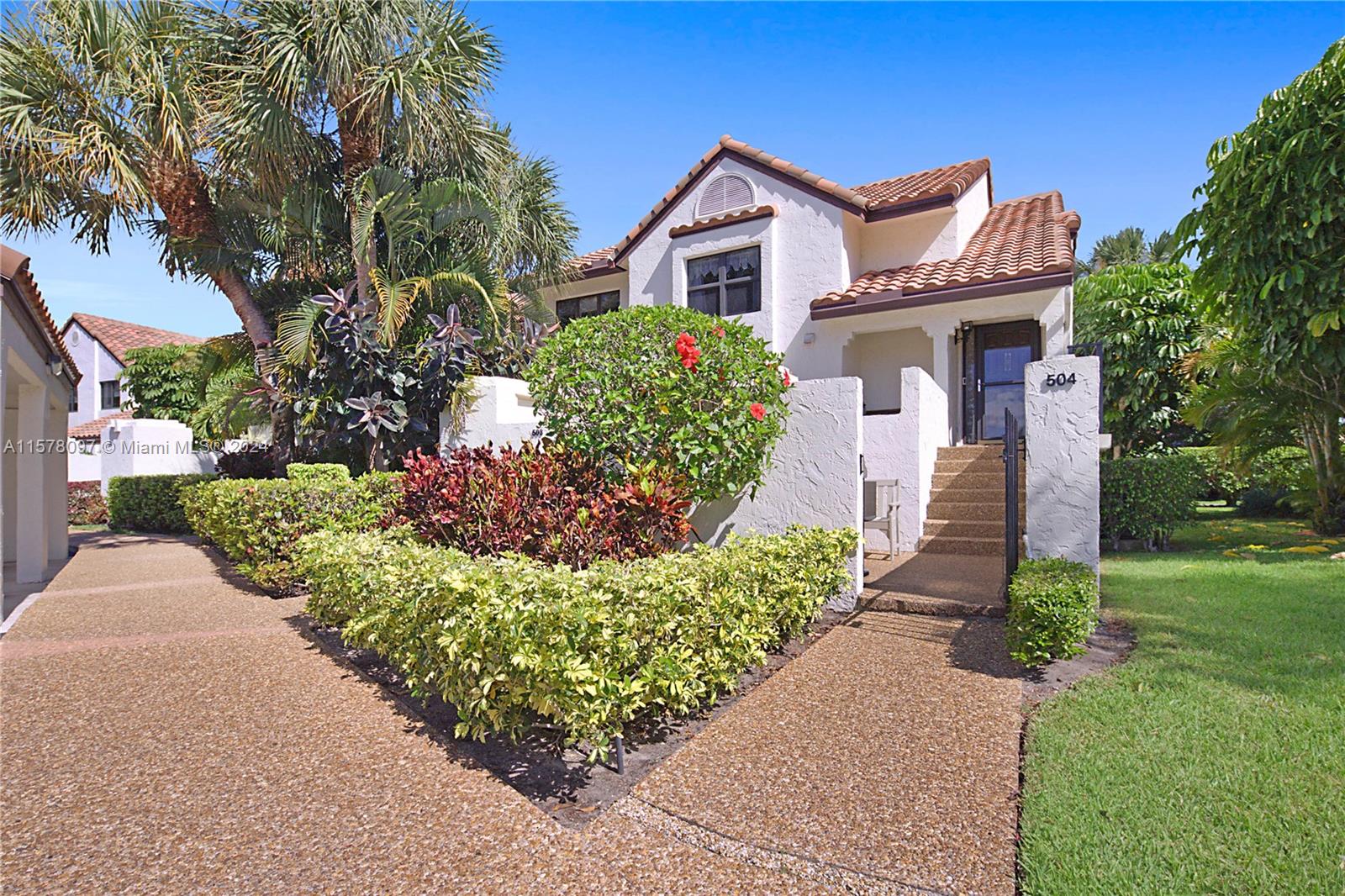 7864 Granada Place, Unit 504 Boca Raton, FL 33433 - Photo 2 of 65 a front view of a house with a yard and a garage