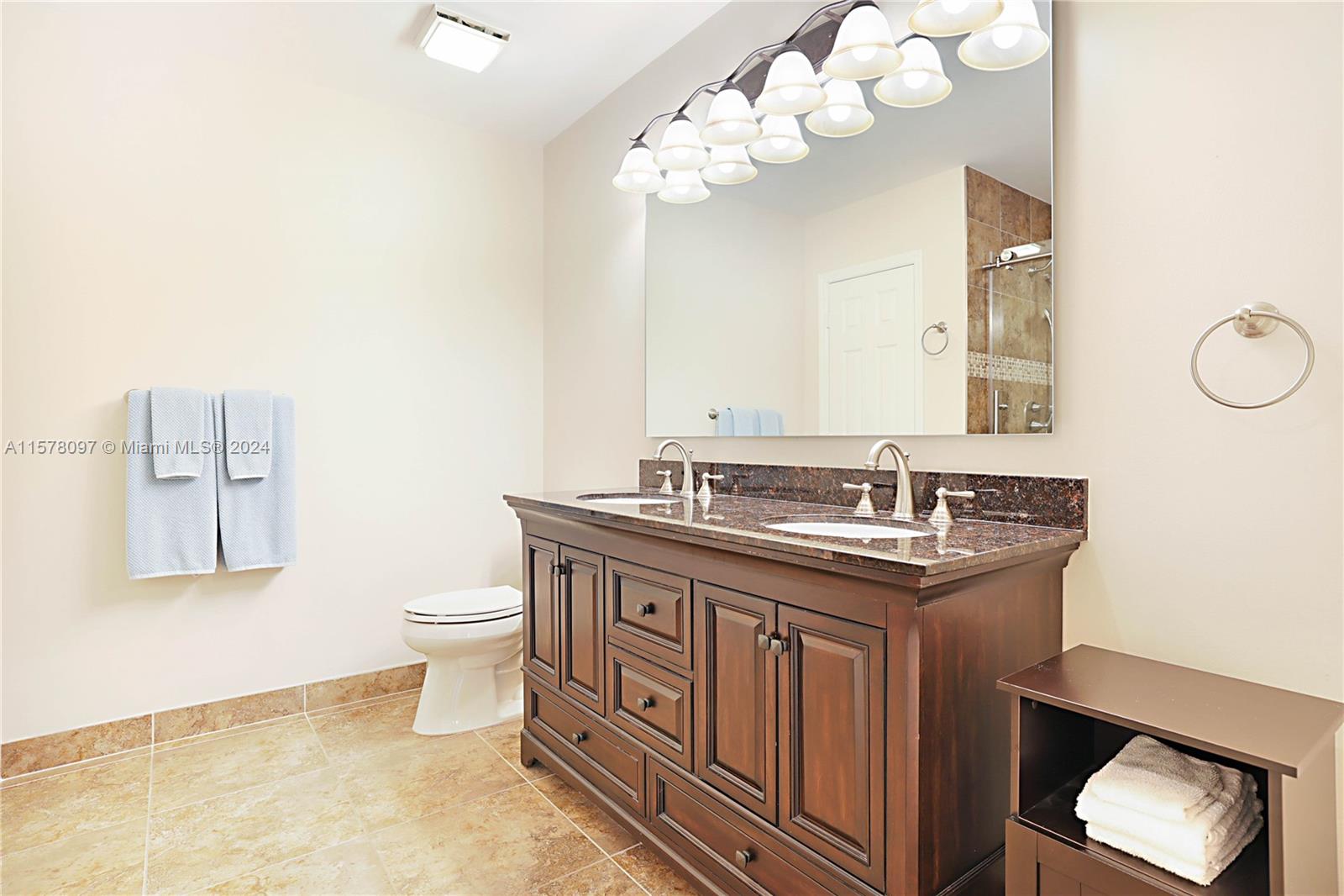 7864 Granada Place, Unit 504 Boca Raton, FL 33433 - Photo 34 of 65 a bathroom with a granite countertop sink a toilet and a mirror