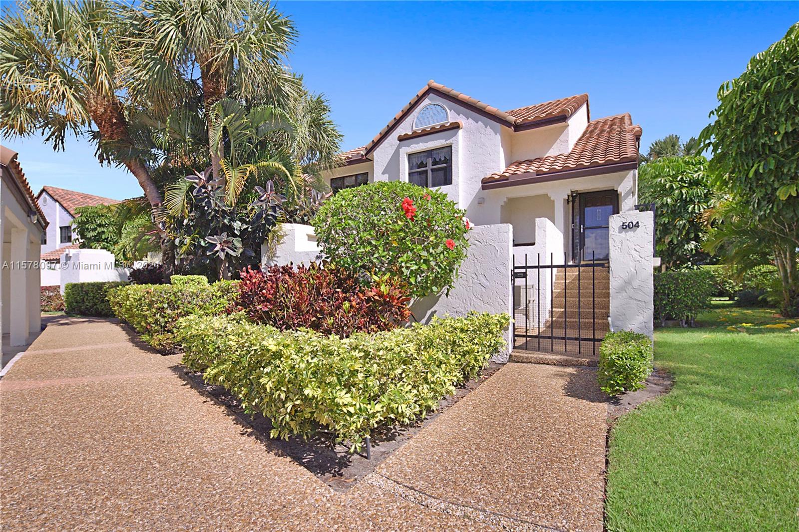 7864 Granada Place, Unit 504 Boca Raton, FL 33433 - Photo 39 of 65 a front view of a house with a yard and a garage