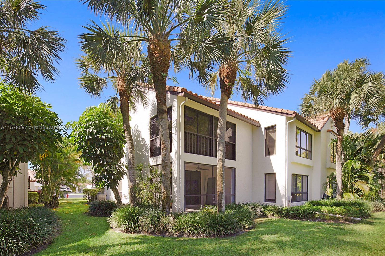 7864 Granada Place, Unit 504 Boca Raton, FL 33433 - Photo 41 of 65 front view of house with a yard and palm trees