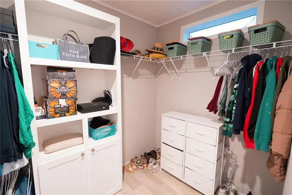 a view of walk in closet with clothes and shoes
