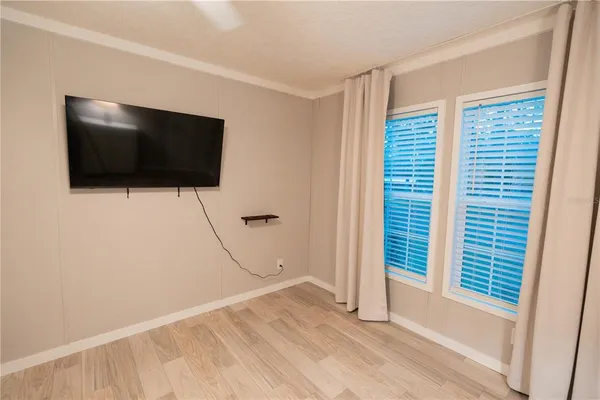 a view of a livingroom with wooden floor and a flat screen tv