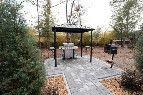 a backyard of a house with table and chairs under an umbrella
