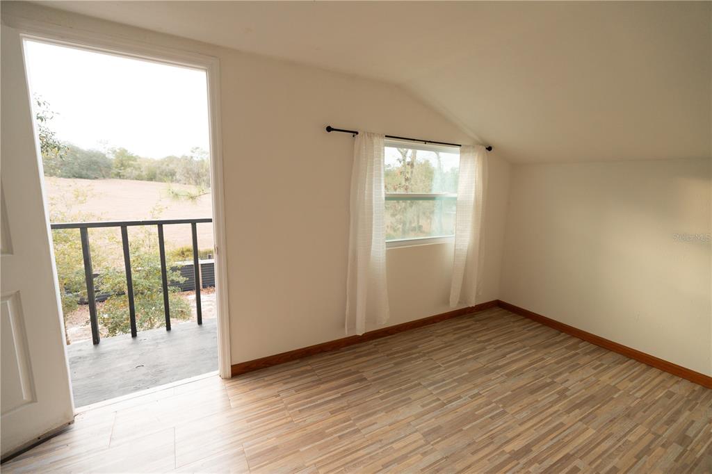 7670 Northeast 97th Court Bronson, FL 32621 - Photo 31 of 58 an empty room with wooden floor and windows