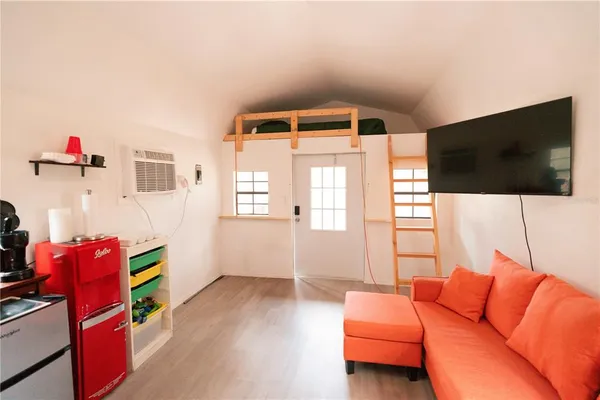 a view of road with large trees and wooden fence
