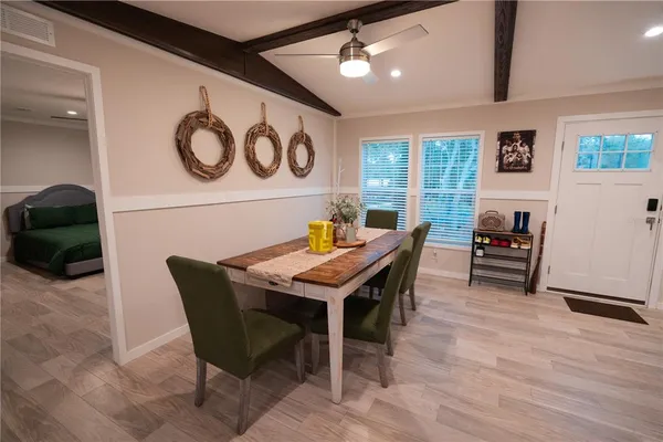 a living room with a table chairs and a refrigerator