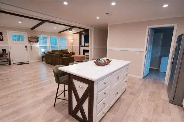 a kitchen with stainless steel appliances kitchen island granite countertop a table chairs sink and wooden floor