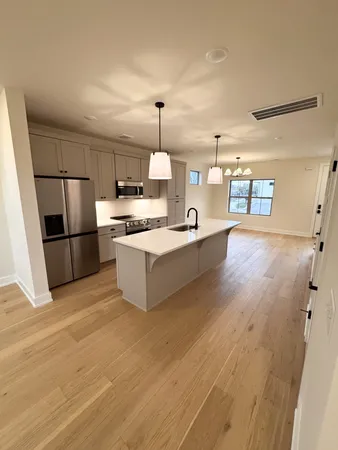 a kitchen with stainless steel appliances granite countertop a refrigerator a stove and a sink