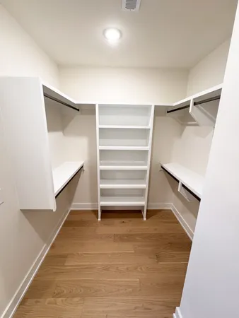 a view of walk in closet with empty racks