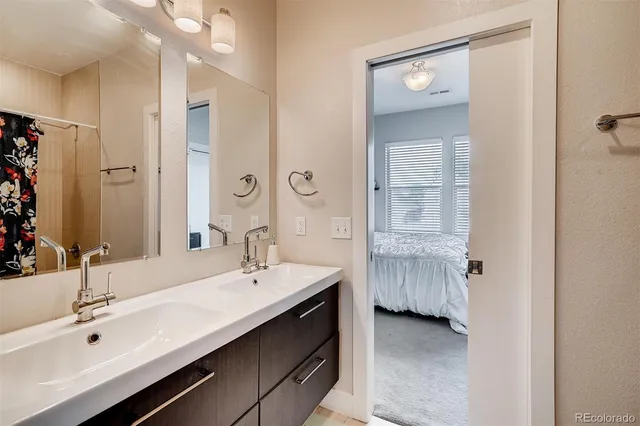 a en suite bathroom with a double vanity sink a large mirror and a shower