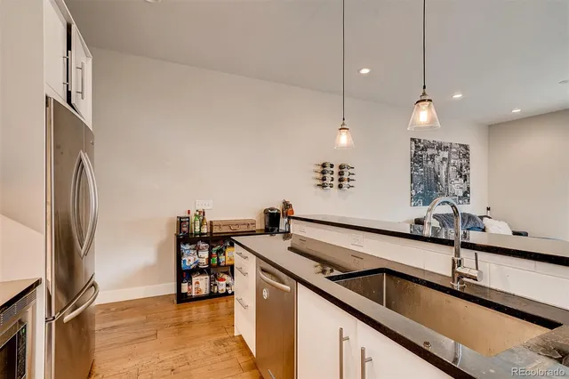 a kitchen with stainless steel appliances granite countertop a sink a stove and a refrigerator