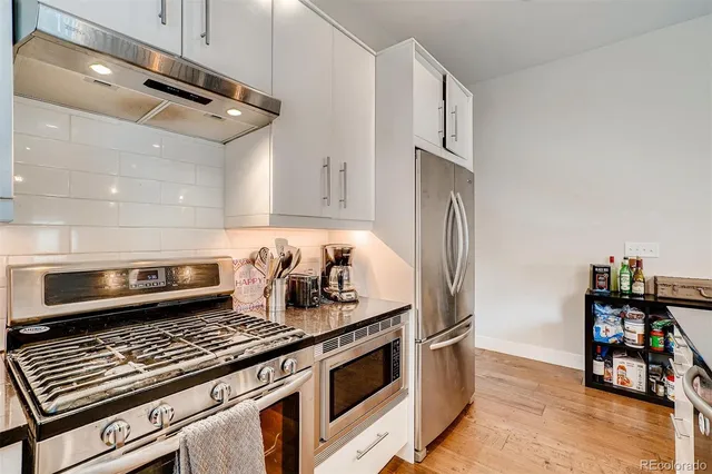 a kitchen with stainless steel appliances granite countertop a stove and a refrigerator