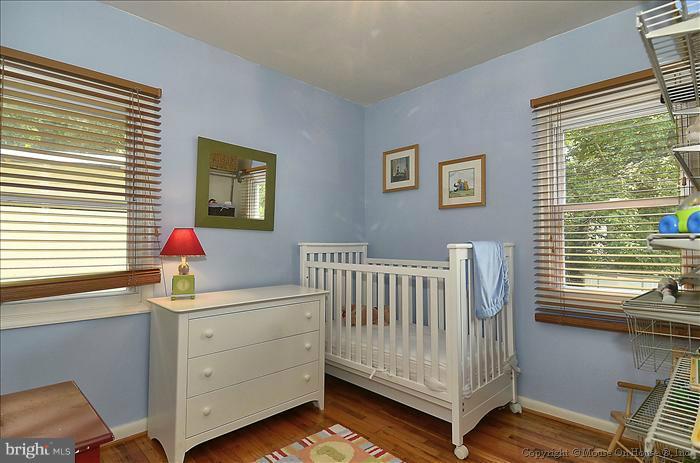 11708 Idlewood Road Silver Spring, MD 20906 - Photo 18 of 21 a bedroom with a baby bed a window and dresser
