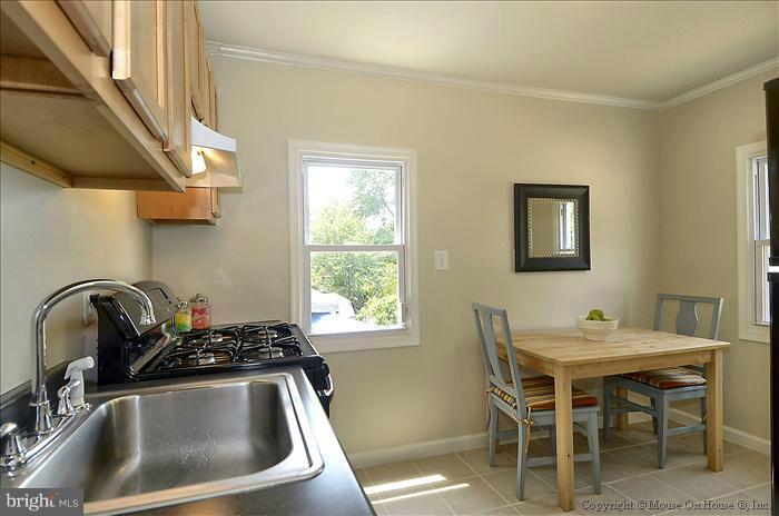 11708 Idlewood Road Silver Spring, MD 20906 - Photo 3 of 21 a kitchen with a sink cabinets and dining table