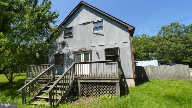 a view of house with backyard and deck