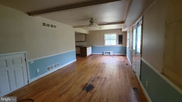 wooden floor in an empty room with a window