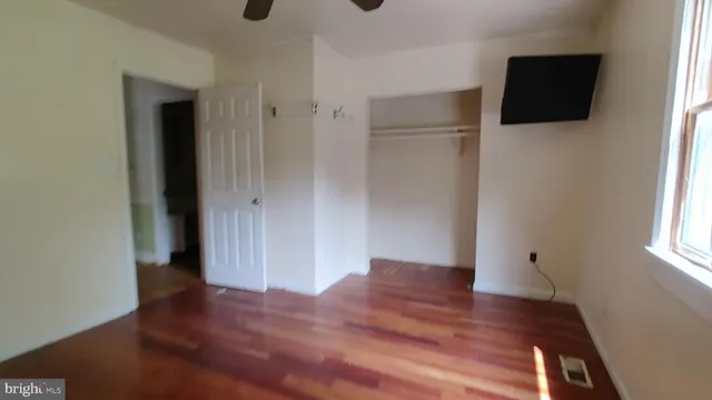 a view of a livingroom with wooden floor and window