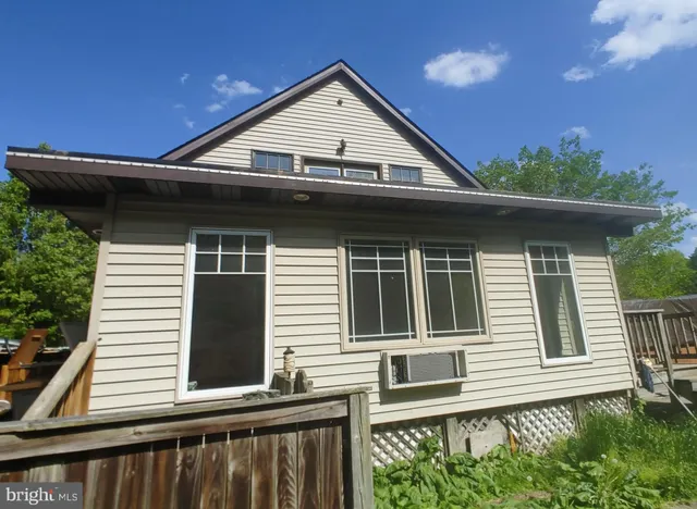 a view of a house with large windows and a small yard