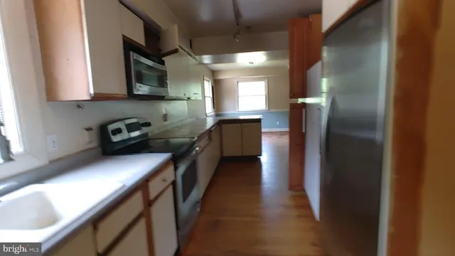 a kitchen with stainless steel appliances granite countertop a refrigerator a stove a sink and a microwave oven