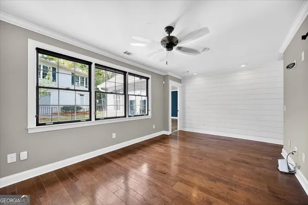 a view of an empty room with a window and wooden floor