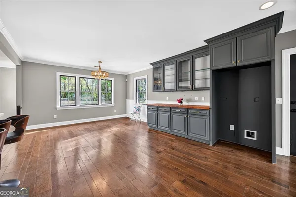 a view of an empty room with wooden floor fireplace and a window