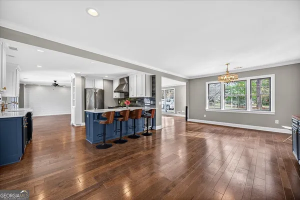 a view of a kitchen with refrigerator and wooden floor
