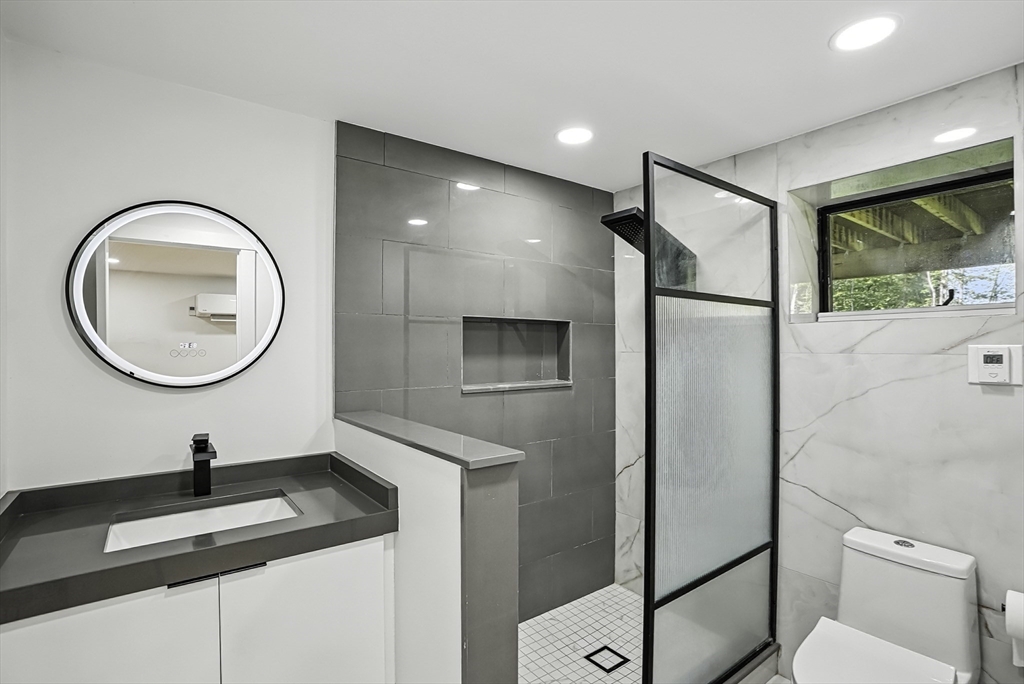 68 Pearl Street Upton, MA 01568 - Photo 31 of 37 a bathroom with a granite countertop sink a mirror and a shower