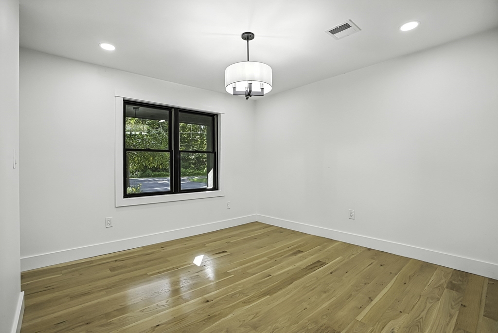68 Pearl Street Upton, MA 01568 - Photo 10 of 37 an empty room with wooden floor cabinet and windows