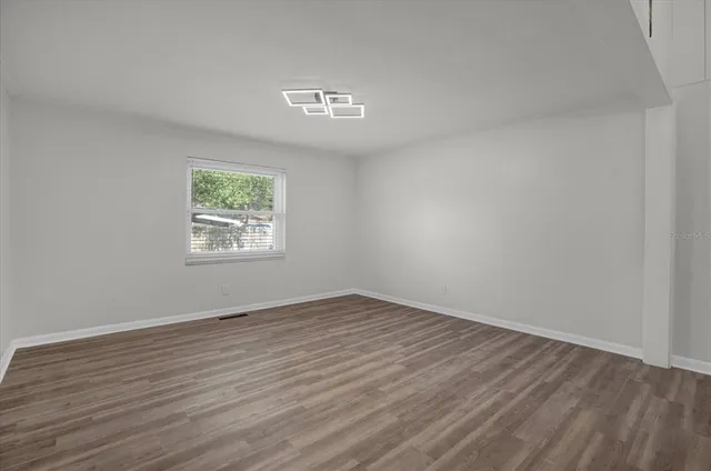 a view of a kitchen with wooden floor and a refrigerator