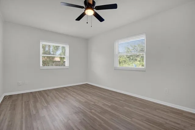 a view of a big room with wooden floor and windows
