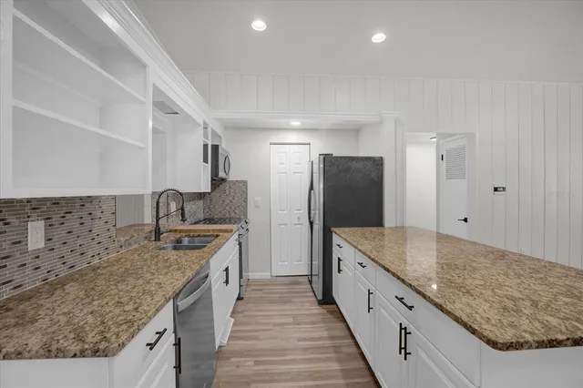 a kitchen with sink stove and cabinets