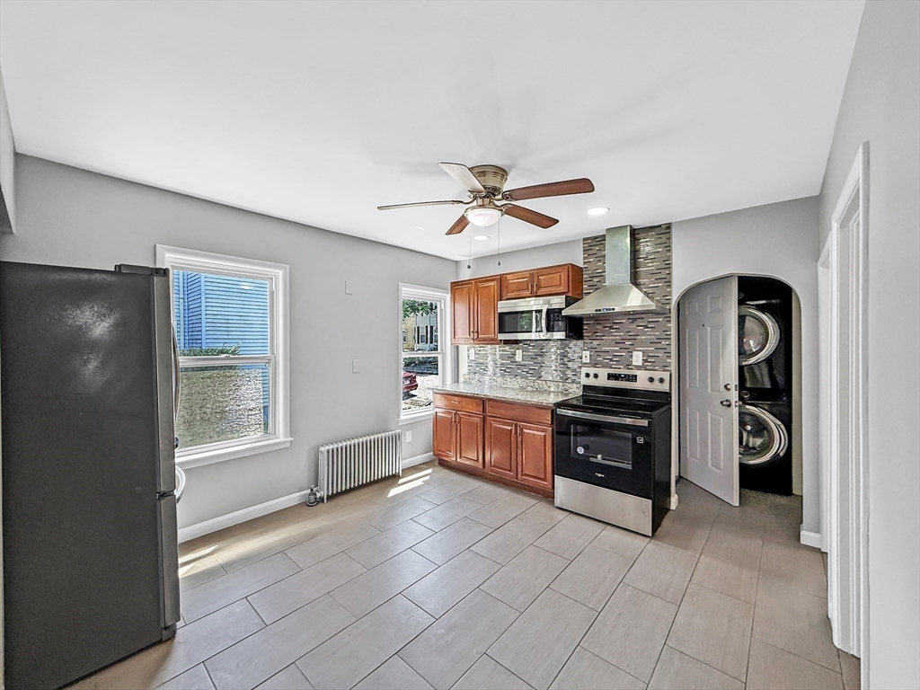70 Cutler Street Worcester, MA 01604 - Photo 11 of 42 a large kitchen with stainless steel appliances granite countertop a refrigerator a stove and a sink with wooden floor