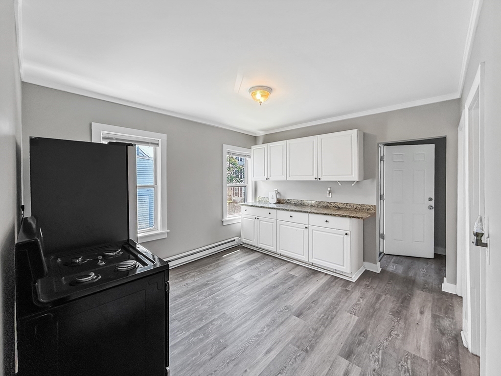 70 Cutler Street Worcester, MA 01604 - Photo 28 of 42 a kitchen with granite countertop a refrigerator stove and white cabinets