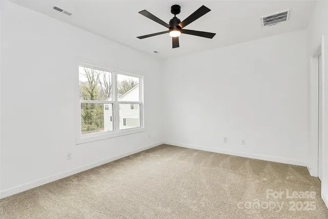 an empty room with a window and a fan