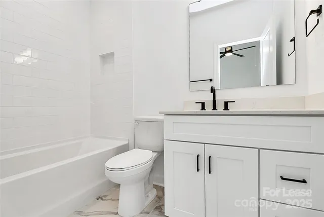 a bathroom with a bathtub sink mirror and toilet
