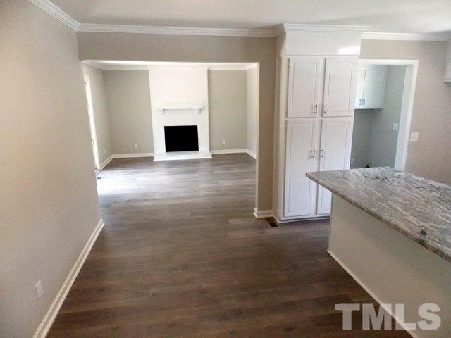 5624 Pelham Road Durham, NC 27713 - Photo 4 of 15 an empty room with wooden floor and cabinet