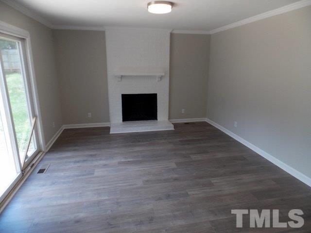 5624 Pelham Road Durham, NC 27713 - Photo 5 of 15 a view of empty room with wooden floor and fireplace
