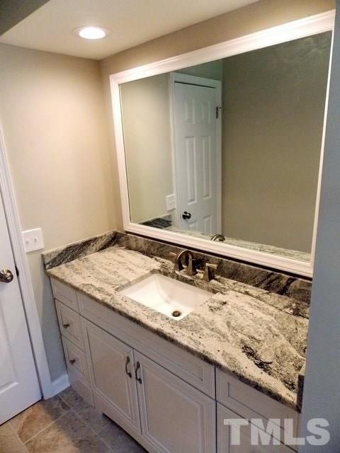 5624 Pelham Road Durham, NC 27713 - Photo 7 of 15 a bathroom with a granite countertop sink and a mirror