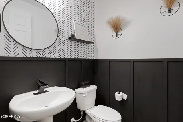 a bathroom with a toilet a sink and mirror